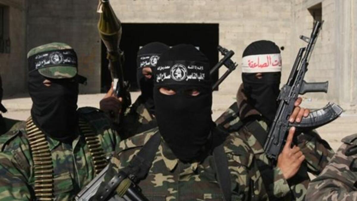 Armed Palestinians are seen following a press conference.