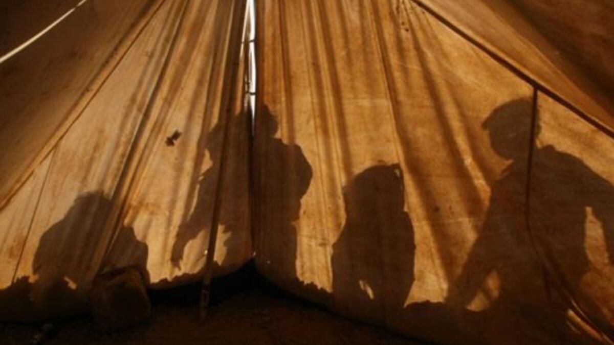 Children of a displaced Palestinian family are reflected on their ten as they play outside on in the Ezbet Abed Rabbo area, that was heavily destroyed during Israel's 22-day offensive on the Gaza Strip two years ago.