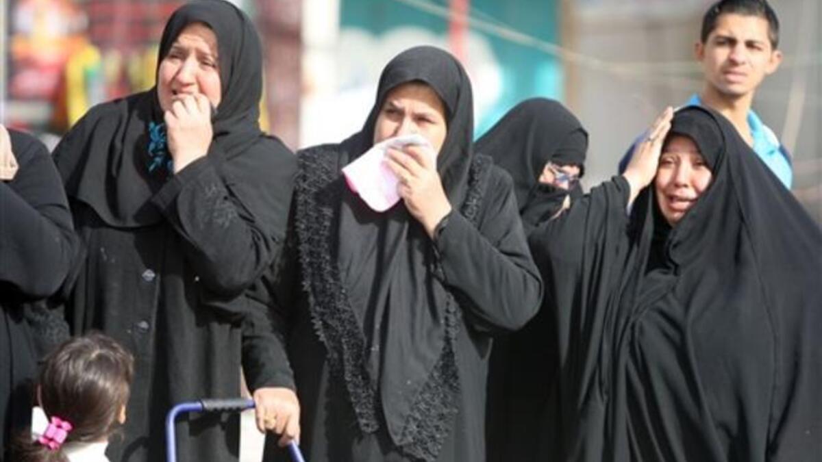 Iraqi Shiite Muslim women grieve as they watch the funeral procession of people killed in a bomb blast that targeted a convoy of pilgrims in the Ghazaliyah district of Baghdad as Shiite Muslims prepare to mark the religious event of Ashura on December 17.