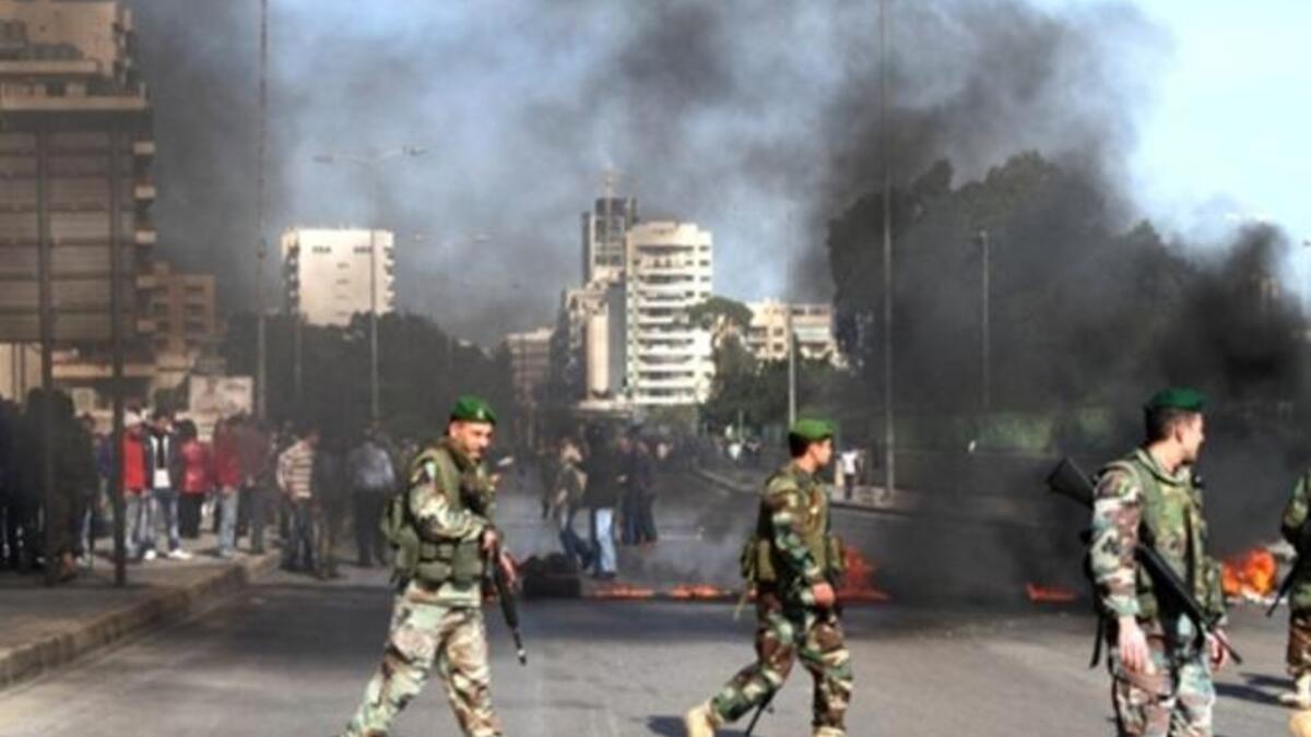 The Lebanese army are seen on the streets as supporters of the Future Movement burn tires in a neighborhood in the capital Beirut during a demonstration in support of the caretaker prime minister Saad Hariri.
