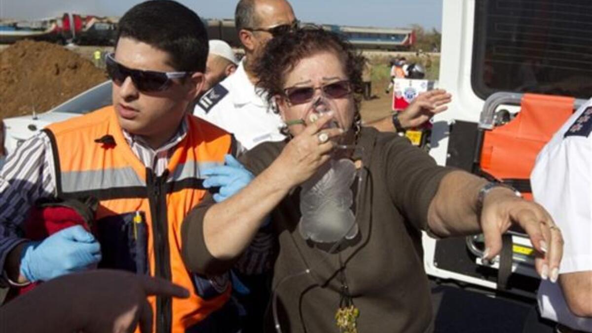 An Israeli woman is evacuated from a burning train coach near Kibbutz Shfaim, close to the Israeli city of Netanya.