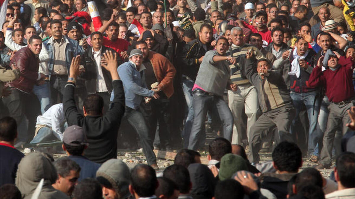 Anti-government protestors (front) clash with supporters of President Mubarak.