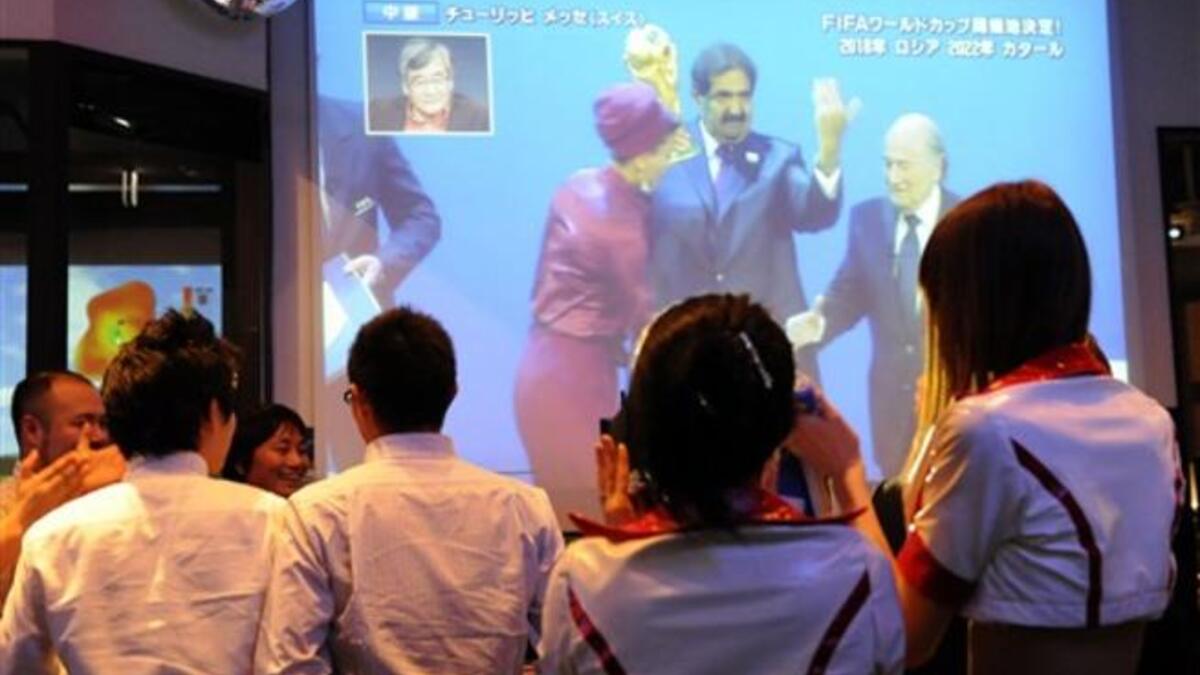 Japanese soccer fans watch television on Qatar's Emir being congratulated by FIFA President Sepp Blatter after they were announced as the 2022 World Cup host country at "M-SPO" sports bar in Tokyo.