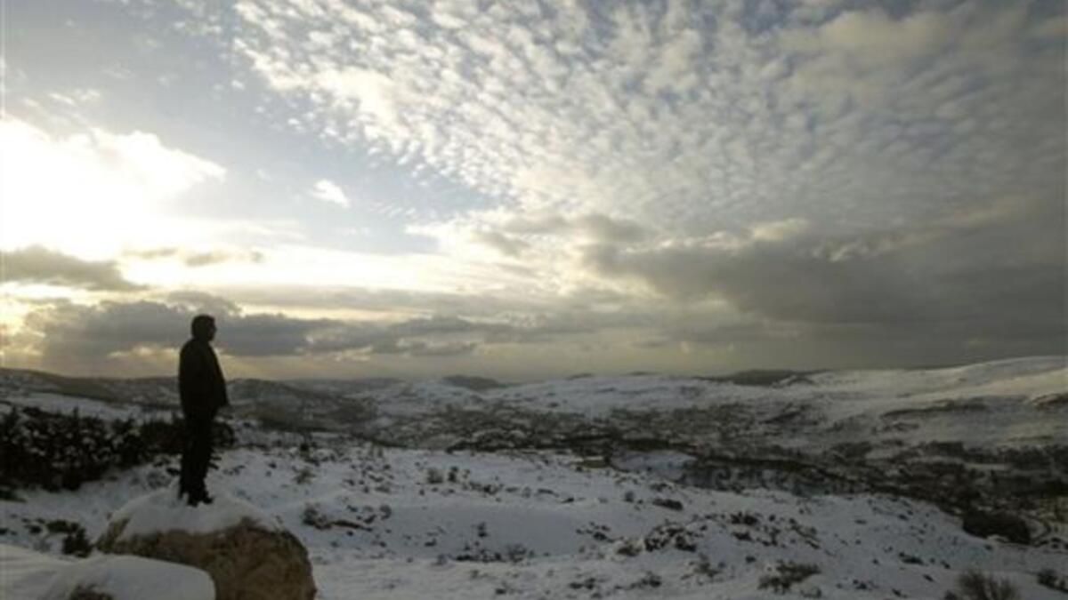 A Lebanese forest ranger observes the sunset from the cedar trees reserve of Baruk in the Shouf mountains, southeast of Beirut, following a snow storm and cold wave which hit the east Mediterranean country after several months of drought.