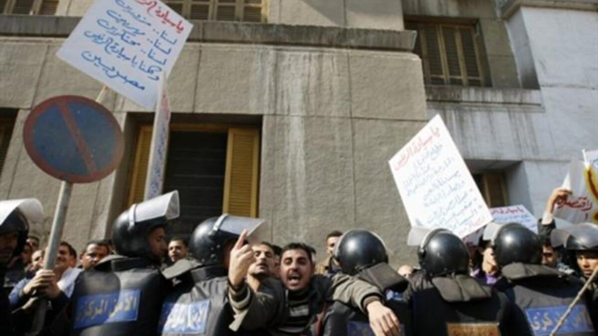 Arabic writing on placard (L) reads: "Mr. President, we are not riggers nor smugglers nor monopolists and we are all Egyptians".
