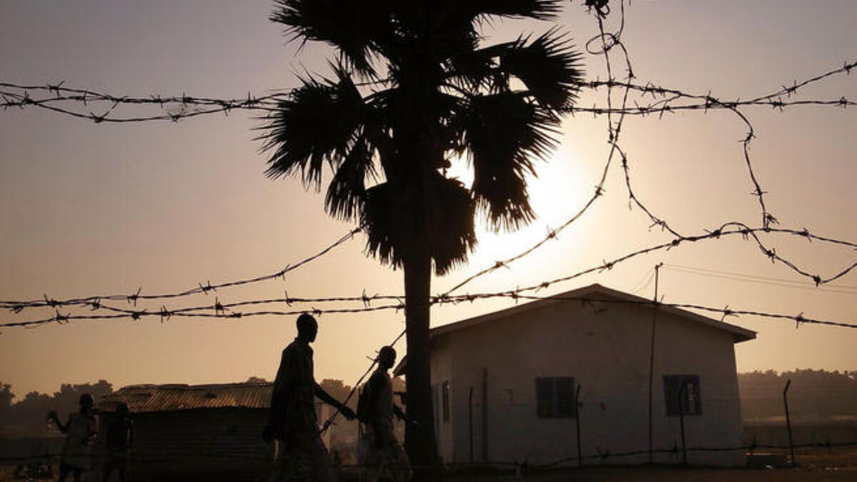 Men walk down a road in an area for displaced Sudanese in the southern Sudanese city of Juba, Sudan.