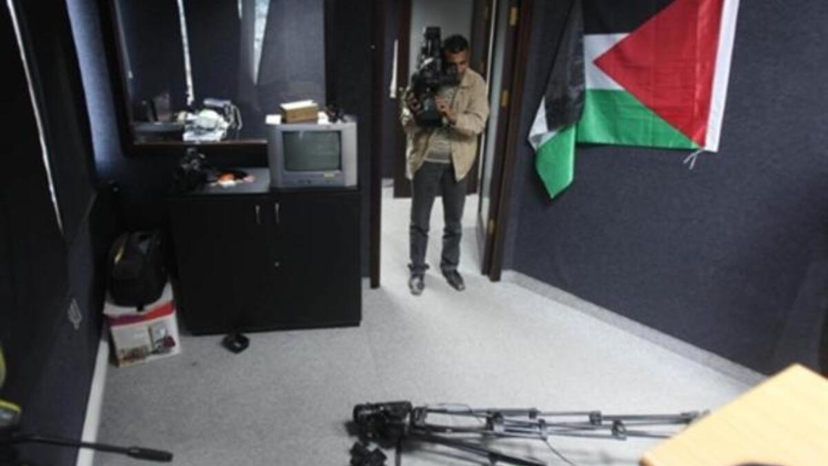 PALESTINE: A press cameraman films damages at a studio at the Palestinian media centre after unknown men attacked its offices, January 26, 2011.