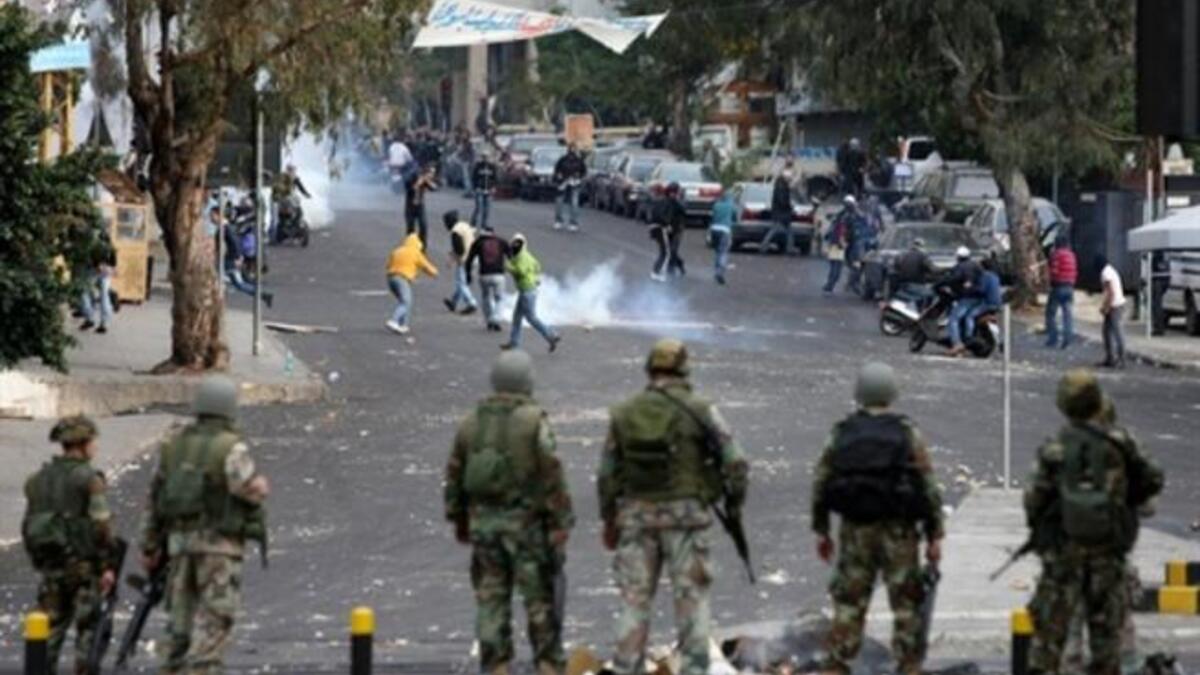 LEBANON: Lebanese soldiers look on as supporters of former Lebanese prime minister Saad Hariri Future Movement flee from tear gas, January 25, 2011.