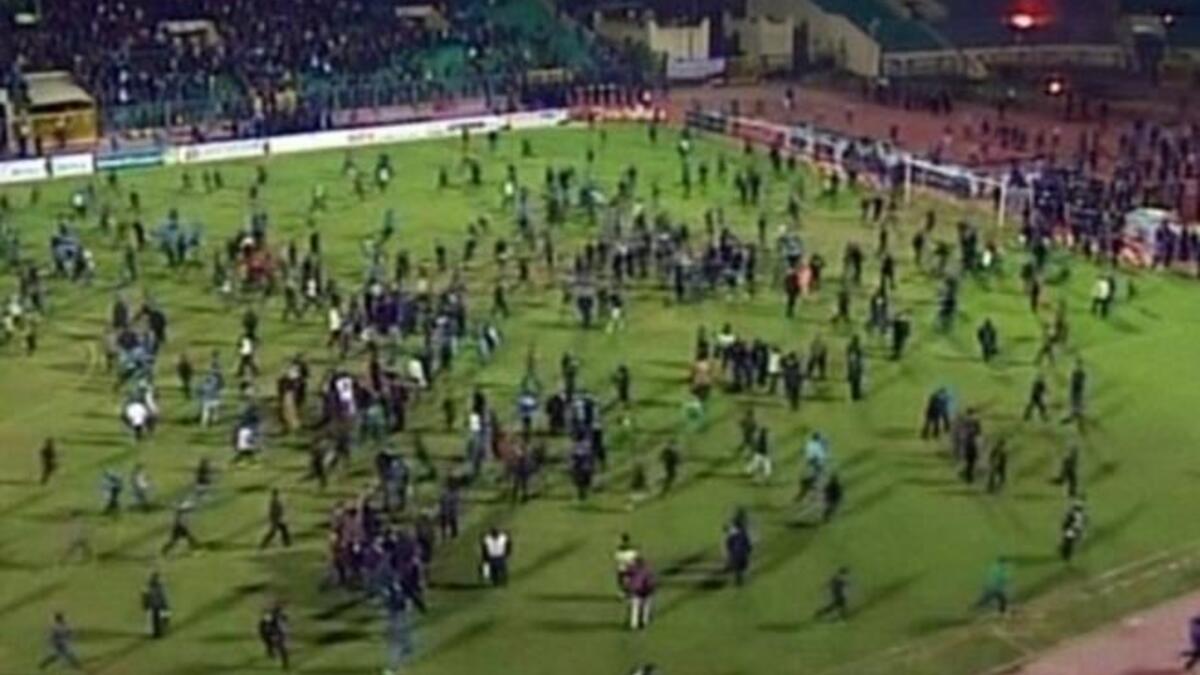 Fans rushing off the football pitch. 'Ultra' trouble-maker, fanatic football fans who had also been involved in the revolution - happy to make sport a politically-charged arena. These Ultras may have been finishing off business from Tahrir, specifically at the 'camel' battle. Al Masry fans held provocative banners aimed at the rival team Al Ahly.