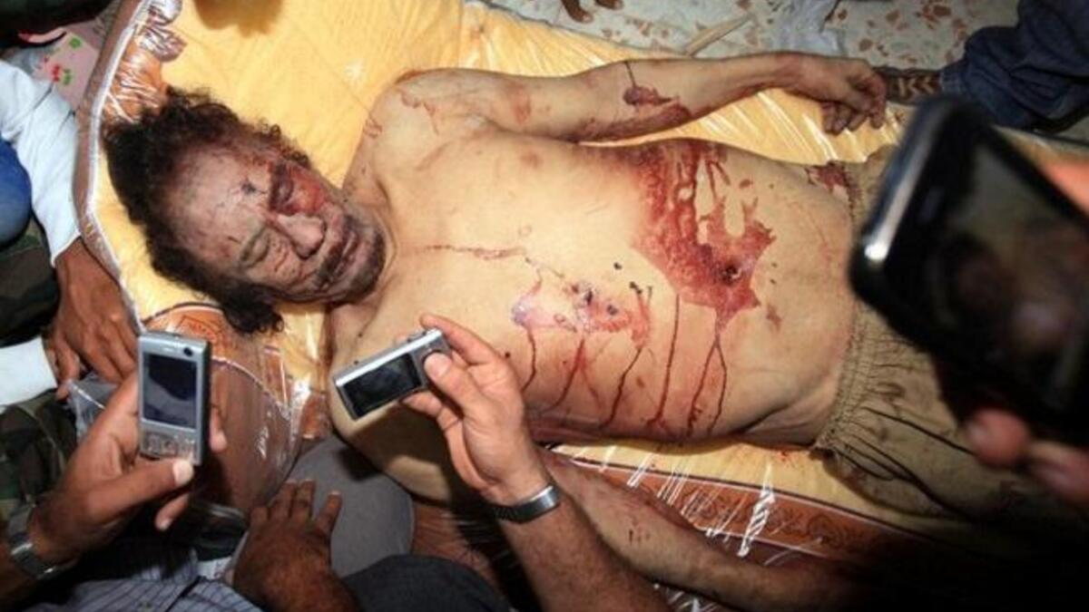 Libyans take pictures with their mobile phones of the body of Muammar Gaddafi in Misrata on October 20, 2011. The veteran strongman was killed as new regime forces crushed the last pocket of resistance in his hometown Sirte, the NTC first reported. The Colonel's final words before impending death,  "Don't shoot, don't shoot" ; "God is Great"!