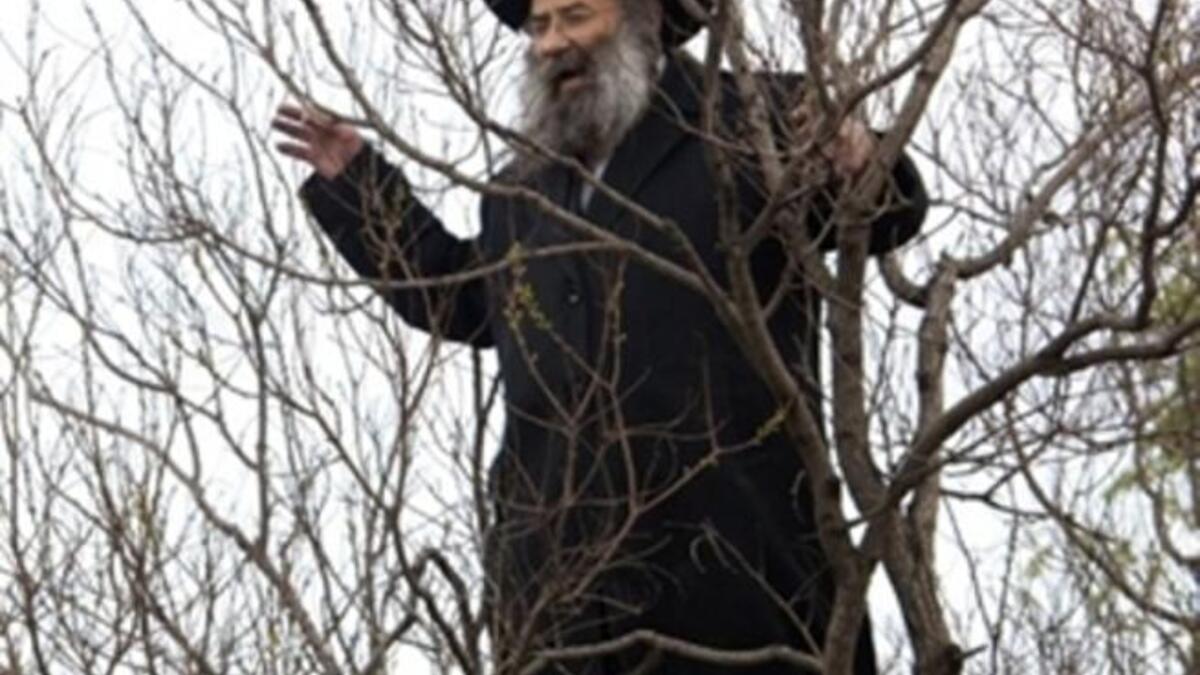 An Ultra Orthodox Jewish man shouts slogans as he watches the scene of an explosion next to a bus near Jerusalem's central bus station.
