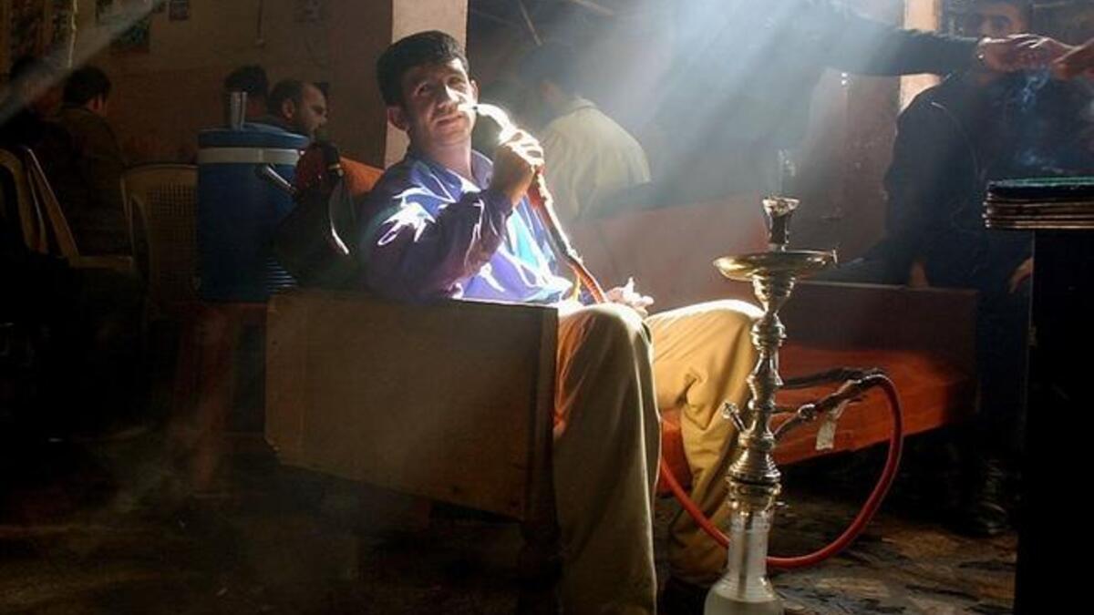 Smoking Ramadan: An Arab smoking a hookah pipe in a sheesha cafe