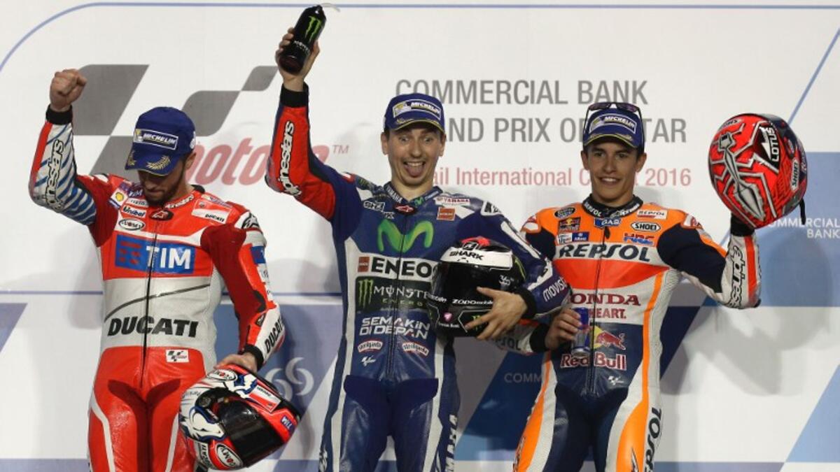 Spanish MotoGP rider Jorge Lorenzo (C) of the Movistar Yamaha MotoGP team celebrates on the podium after winning the Qatar MotoGP race with Italian rider Andrea Dovizioso (L) of the Ducati Team who won second place and Spanish rider Marc Marquez (R) third place at the Losail International Circuit in Doha on March 20, 2016.
KARIM JAAFAR / AFP