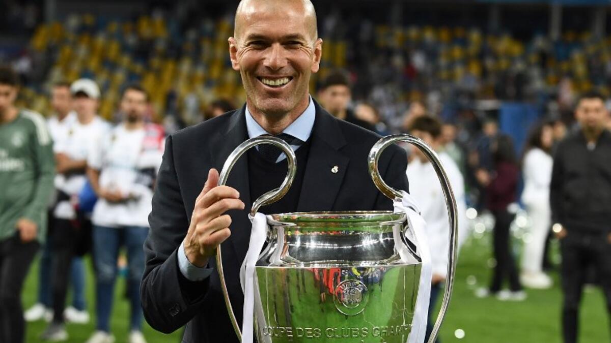 Real Madrid's French coach Zinedine Zidane holds the trophy as he celebrates winning the UEFA Champions League final football match between Liverpool and Real Madrid at the Olympic Stadium in Kiev, Ukraine, on May 26, 2018.
FRANCK FIFE / AFP
