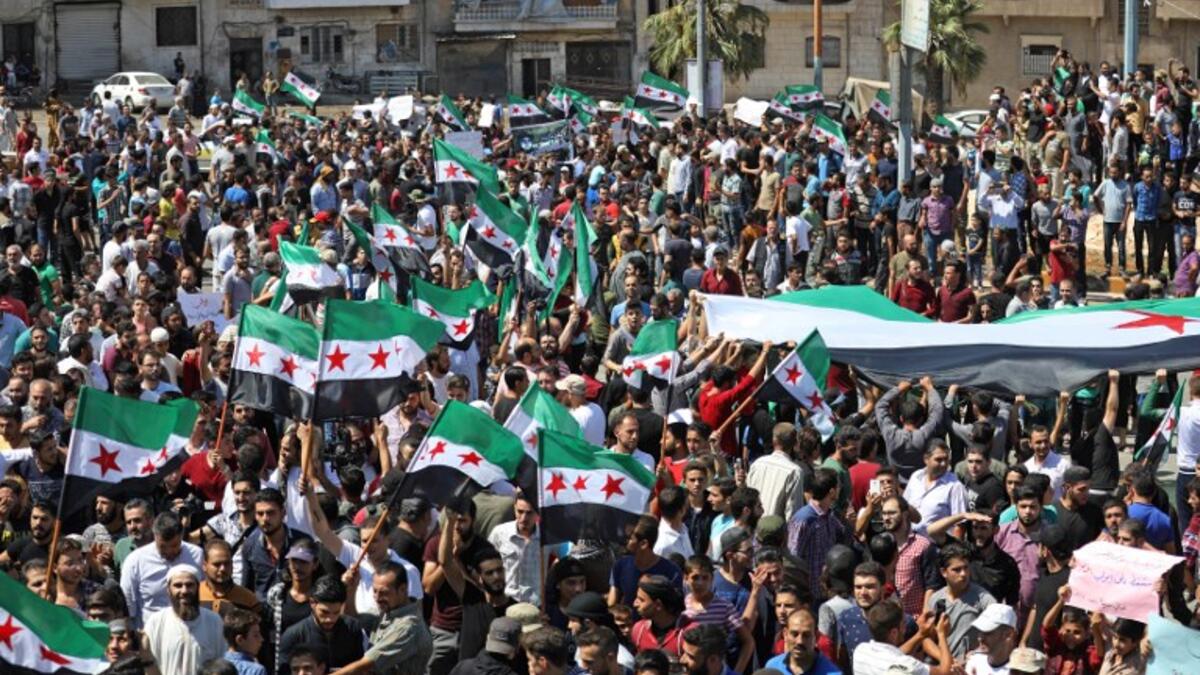 Syrian protesters wave the flag of the opposition as they demonstrate against the regime and its ally Russia, in the rebel-held city of Idlib on September 7, 2018. (OMAR HAJ KADOUR / AFP)