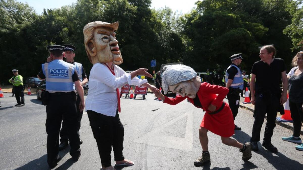 Protesters wearing masks depicting US President Donald Trump (L) and Britain's Prime Minister Theresa May (R) join other protesters against the UK visit of US President Donald Trump demonstrate outside Chequers, the prime minister's country residence, where Trump and May are holding a meeting. (Isabel INFANTES / AFP)