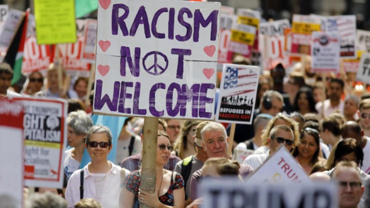Protesters against the UK visit of US President Donald Trump holding up placards as they take part in a march and rally in London on July 13, 2018.  (Tolga AKMEN / AFP)