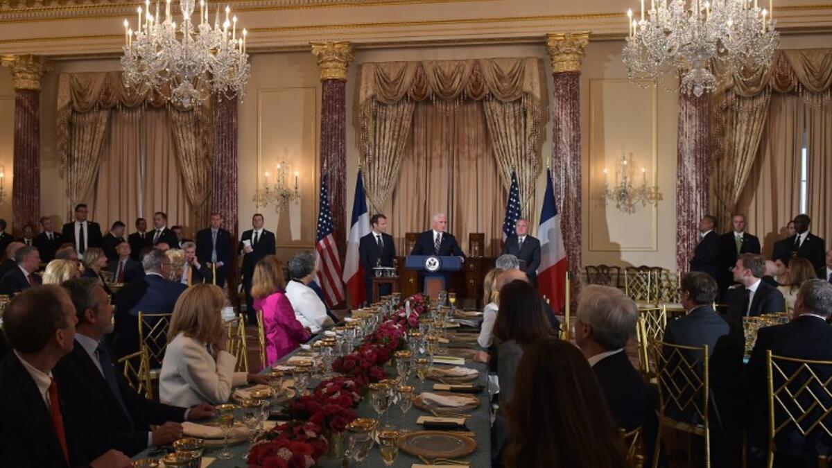 French President Emmanuel Macron (L) looks on as US Vice President Mike Pence speaks during a luncheon at the US State Department in Washington, DC on April 24, 2018. 
Andrew CABALLERO-REYNOLDS / AFP
