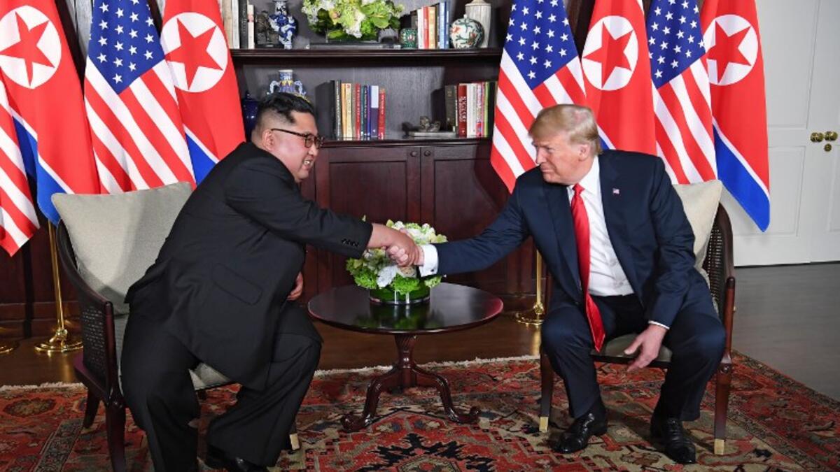 US President Donald Trump (R) shakes hands with North Korea's leader Kim Jong Un (L) as they sit down for their historic US-North Korea summit, at the Capella Hotel on Sentosa island in Singapore on June 12, 2018. (SAUL LOEB / AFP)