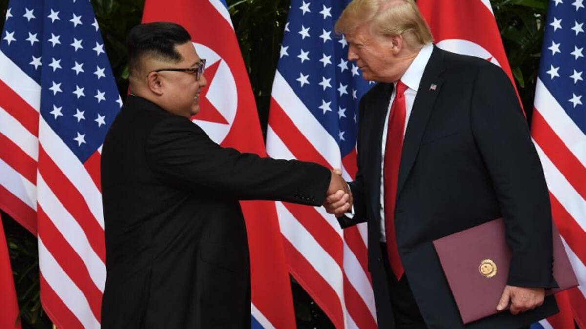 North Korea's leader Kim Jong Un (L) shakes hands with US President Donald Trump (R) after taking part in a signing ceremony at the end of their historic US-North Korea summit, at the Capella Hotel on Sentosa island in Singapore on June 12, 2018. (Anthony WALLACE / POOL / AFP)