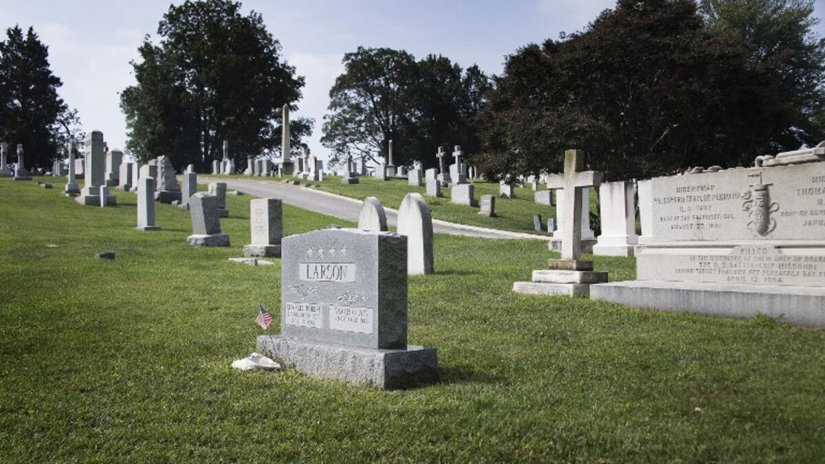 A flag is placed at the base of the tombstone of US Navy admiral Charles "Chuck" Larson at the US Naval Academy in Annapolis, Maryland, on August 24, 2018, near where US Senator John McCain will be laid to rest next. (AFP)