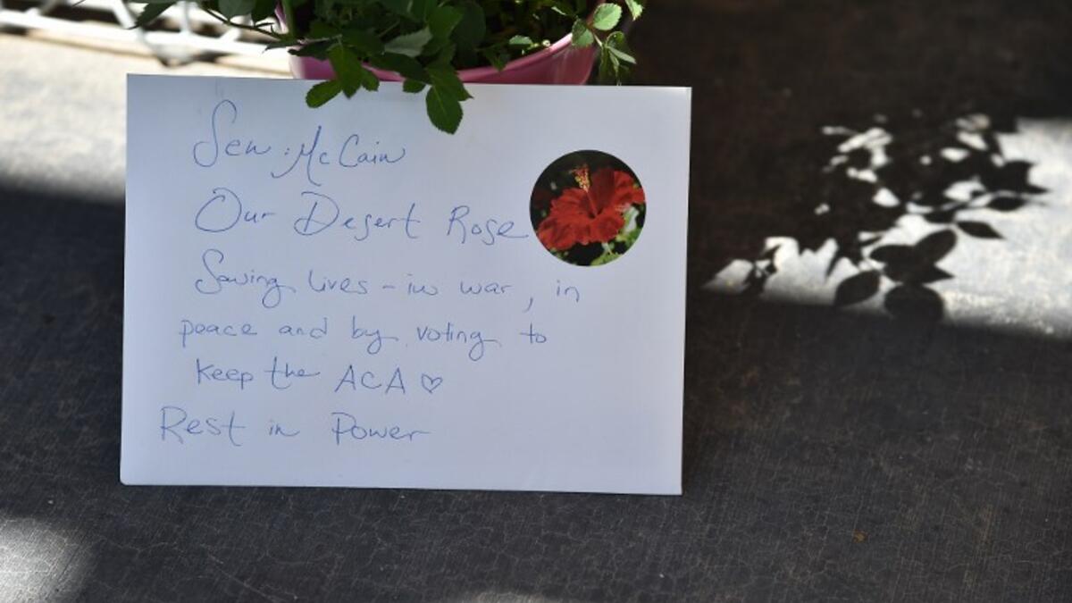 A handwritten note is seen at a makeshift memorial remembering Senator John McCain outside McCain's office in Phoenix, Arizona, August 27, 2018. (Robyn Beck / AFP)
