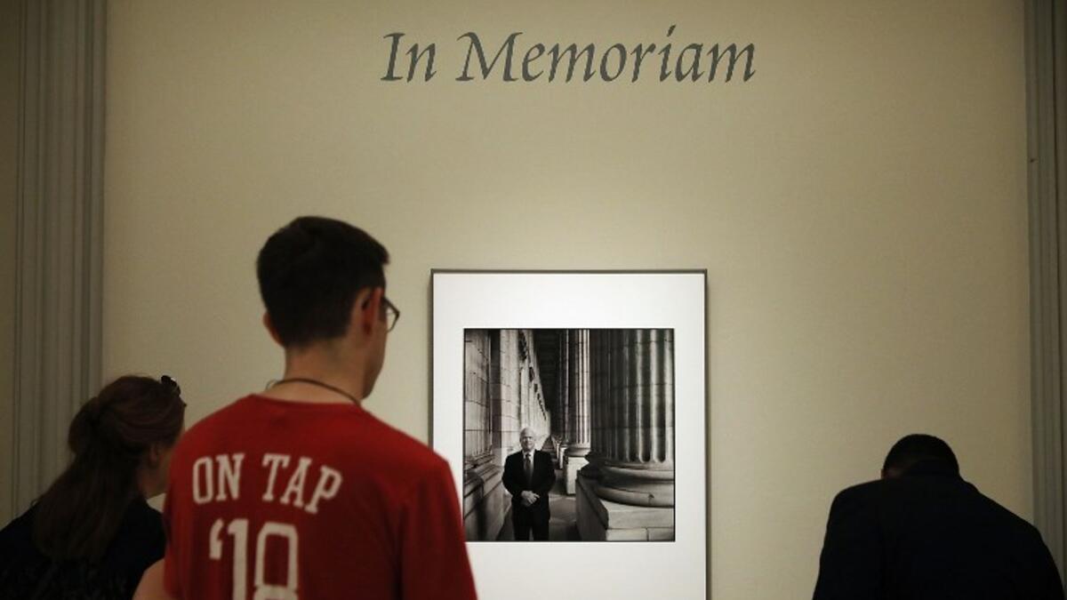 Visitors pause to look at a photograph of Sen. John McCain (R-AZ) on display at the Smithsonian National Portrait Gallery August 27, 2018 in Washington, DC. (AFP)