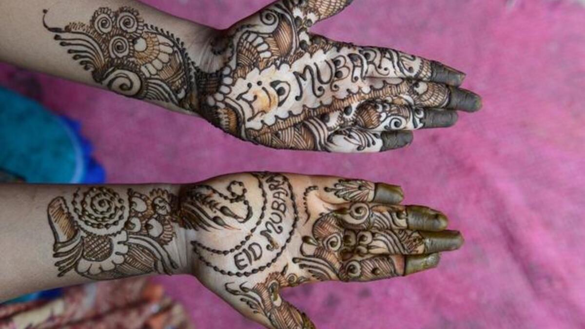 A customer displays her hands styled with henna that says 'Eid Mubarak' (Happy Eid) in Hyderabad, India. (GETTY)