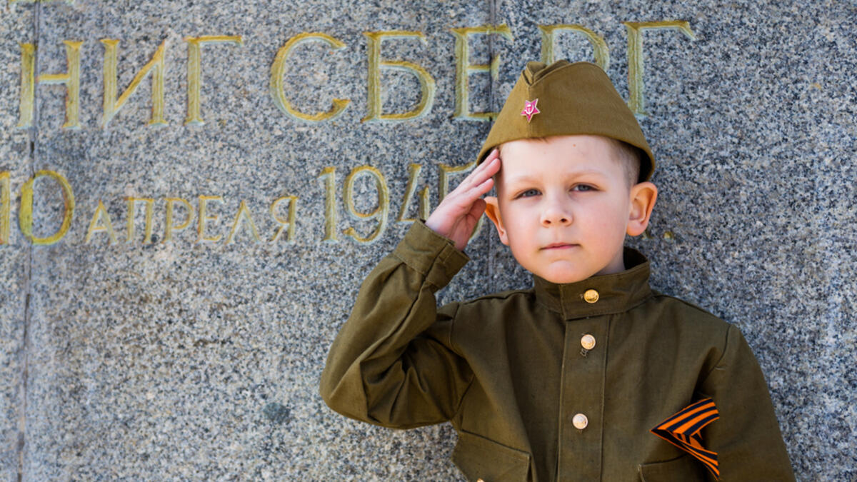 Little boy in military uniform with flowers at the military memorial of the Victory Day on May 9 in Russia, Kaliningrad , Victory Park, May 2018 (Shutterstock/File Photo)