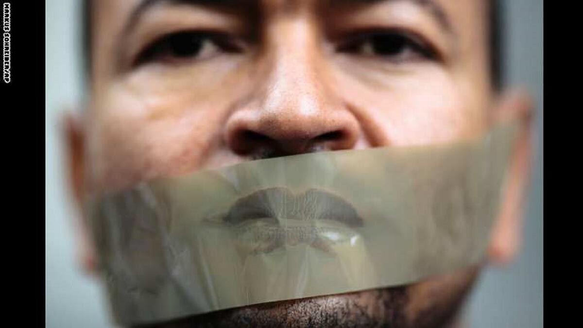 رجل يضع شريطاً لاصقاً على فمه في مظاهرة بألمانيا احتجاجاً على احتجاز الصحفي بقناة الجزيرة، أحمد منصور، من قبل السلطات الألمانية، وذلك بناءً على طلب من الحكومة المصرية، حيث تم الإفراج عنه في وقت لاحق.