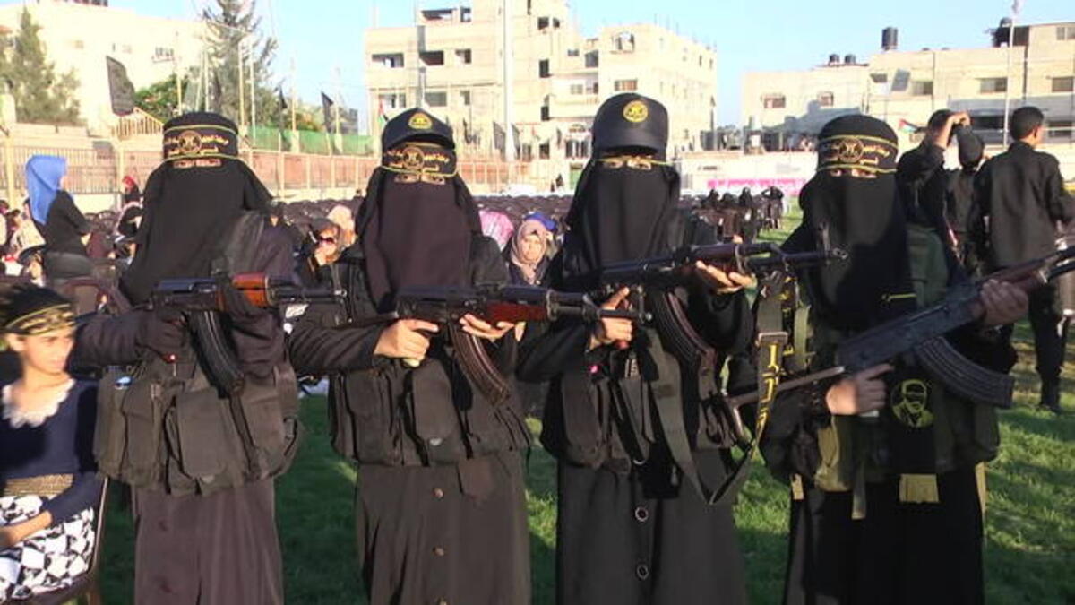 The women with their weapons during the exercise as spectators look on (i.dailymail)