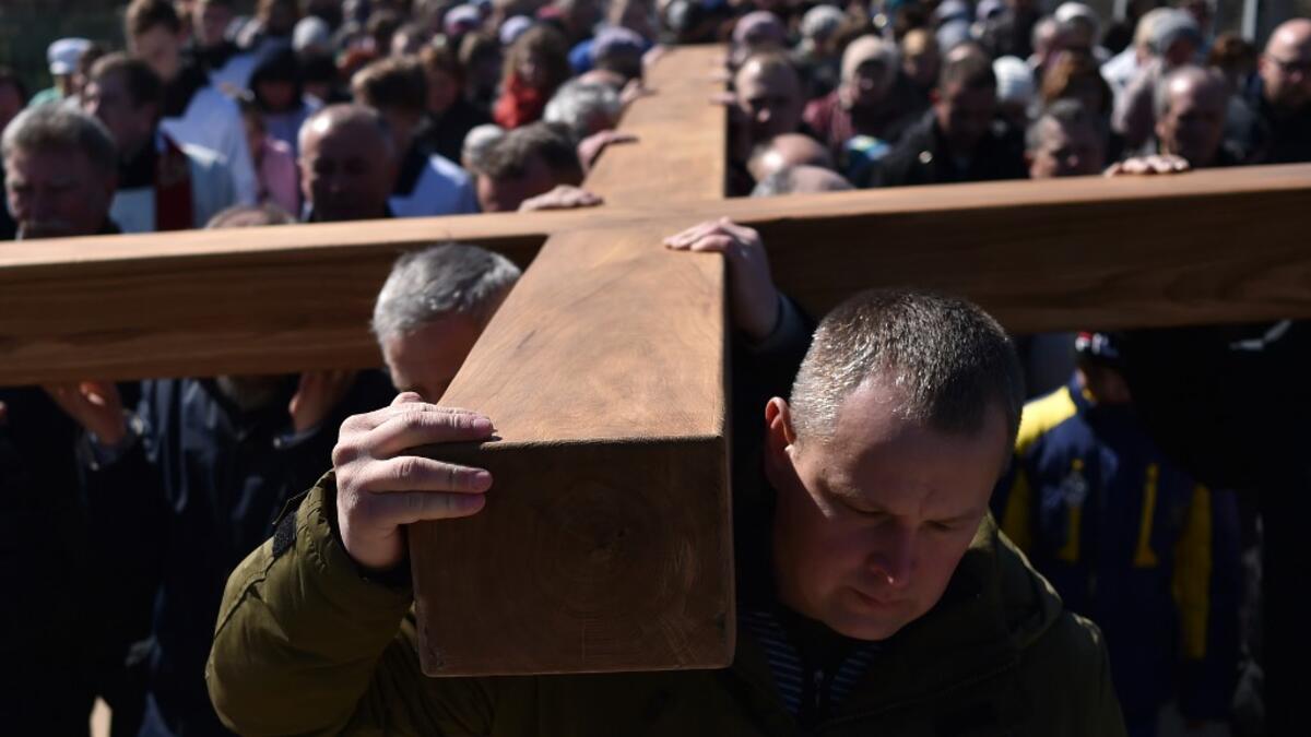 Catholic believers carry a giant cross on April 14, 2019 in the town of Ashmiany, some 130 km northwest of Minsk, during a Palm Sunday celebration which mark a week before eastern.  Sergei GAPON / AFP