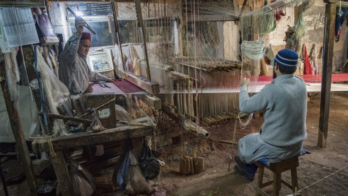 Abdelkader Ouazzani, the last of Morocco's brocade master weavers, displays tapestry at his workshop in the old city of Fez on April 10, 2019. His skilfull hands intricately create shimmering silk fabrics, enhanced with gold or silver thread, for bridal jewellery, designer creations or high-end furnishings. FADEL SENNA / AFP