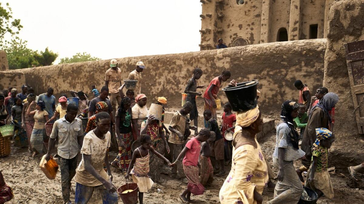 People take part in the annual rendering of the Great Mosque of Djenne in central Mali  MICHELE CATTANI / AFP