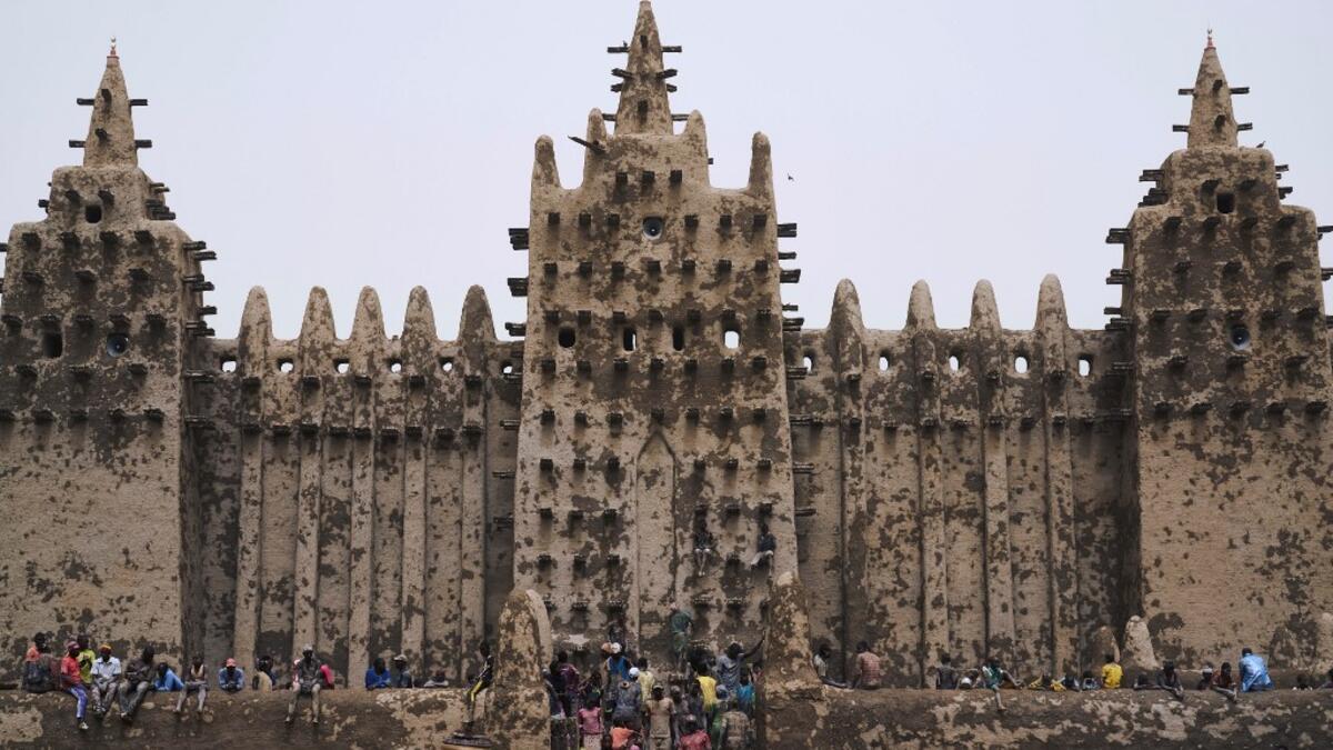 People take part in the annual rendering of the Great Mosque of Djenne in central Mali  MICHELE CATTANI / AFP