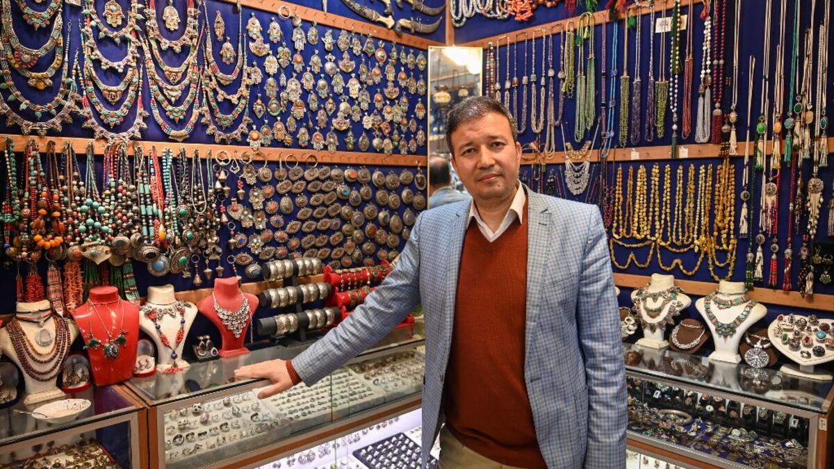 Expert Afghan jeweler Khalil Nuri poses for a picture in his shop at the Grand Bazaar in Istanbul.   OZAN KOSE / AFP