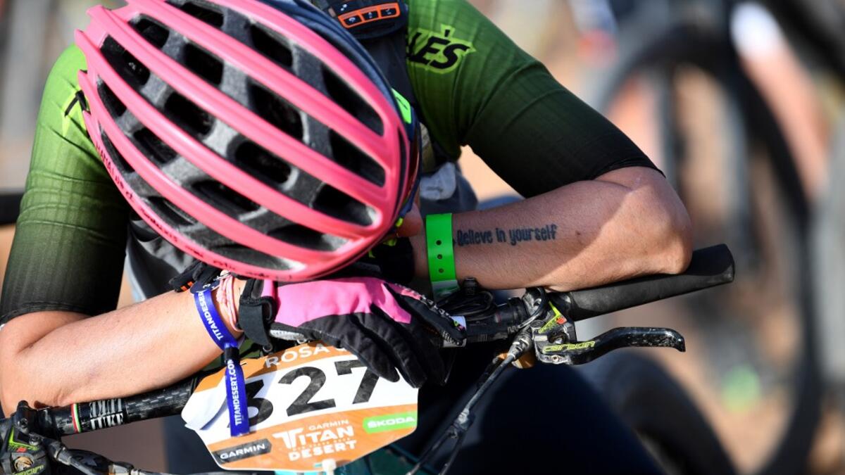 Competitors pay tribute to dceased competitor Fernando Civera in a minute of silence at the bivouac in Ouzina before the start of the cancelled Stage 3 of the 14th edition of Titan Desert 2019 mountain biking race near Merzouga, in Morocco on April 30, 2019. Fernando Civera passed away at km 55 of the stage two, the third stage of Titan Desert 2019 has been cancelled. FRANCK FIFE / AFP