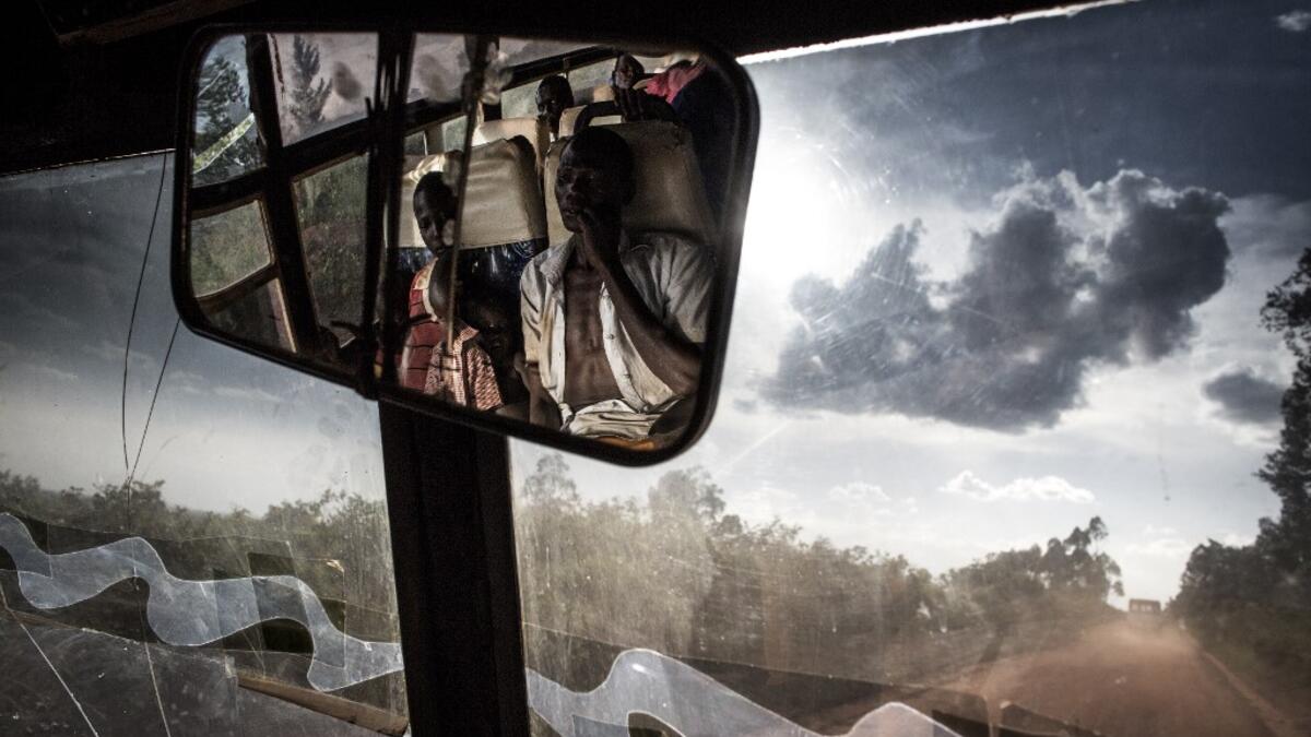 South Sudanese refugees transported by bus from the border of South Sudan to a refugees settlement site in Democratic republic of the Congo (DRC) are seen in the rear-view mirror of the bus JOHN WESSELS / AFP