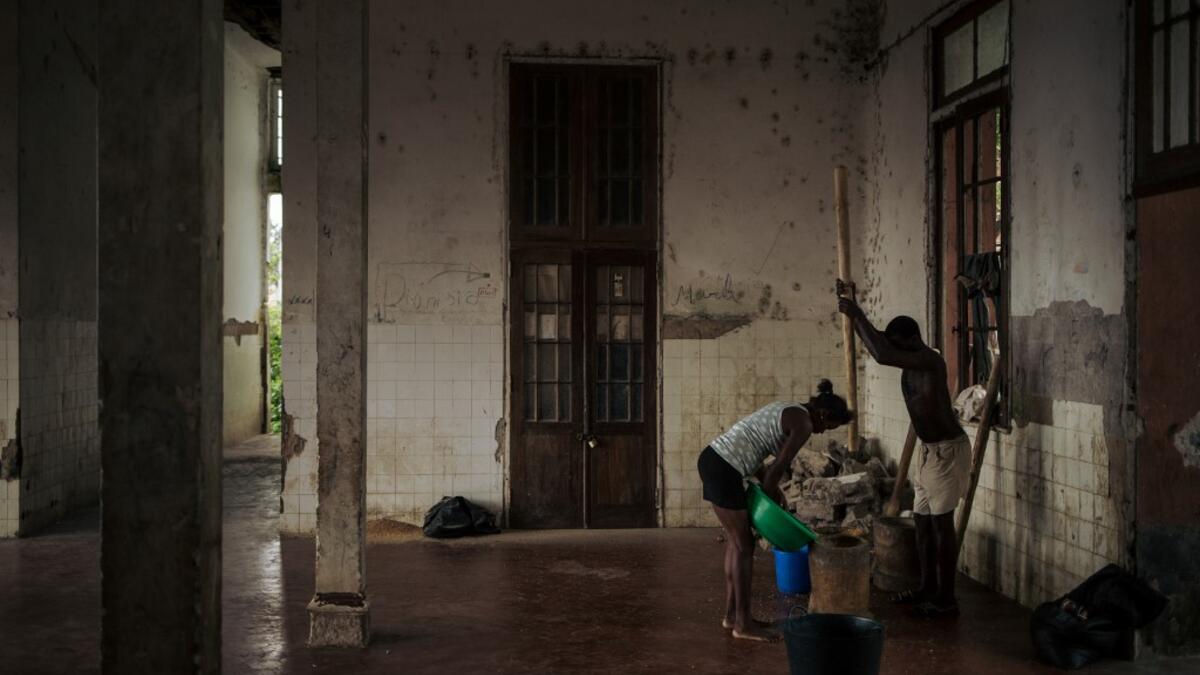 Inhabitants of the roca Agostinho Neto, an abandoned cocoa plantation of Sao Tome and Principe, prepare corn in the former hospital of the roca, on May 29, 2019.  Alexis HUGUET / AFP
