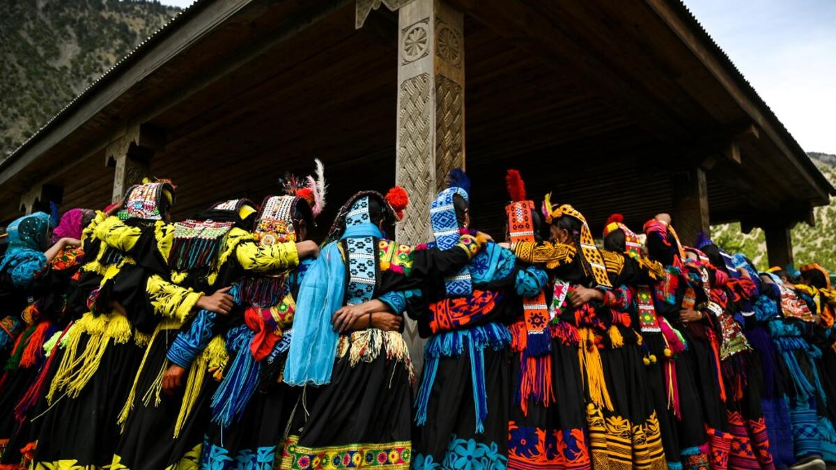 In this picture Kalash women wearing traditional dresses dance to celebrate 'Joshi', a festival to welcome the arrival of spring, at Bumburate village in the mountainous valleys in northern Pakistan. AAMIR QURESHI / AFP