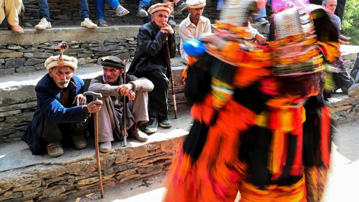 In this picture  Kalash elderly men watch women dancing as they celebrate 'Joshi', a festival to welcome the arrival of spring, at Bumburate village in the mountainous valleys in northern Pakistan.  AAMIR QURESHI / AFP