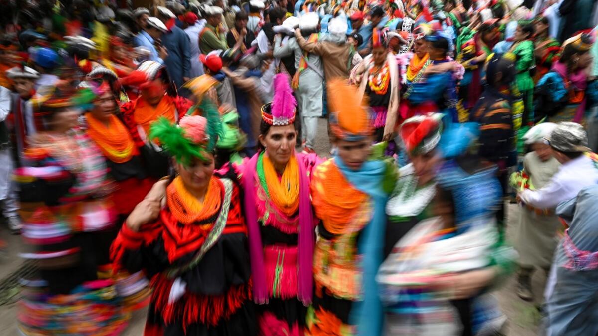 Kalash women wearing traditional dresses dance as they celebrate 'Joshi', a festival to welcome the arrival of spring, at Bumburate village in the mountainous valleys in northern Pakistan.  AAMIR QURESHI / AFP