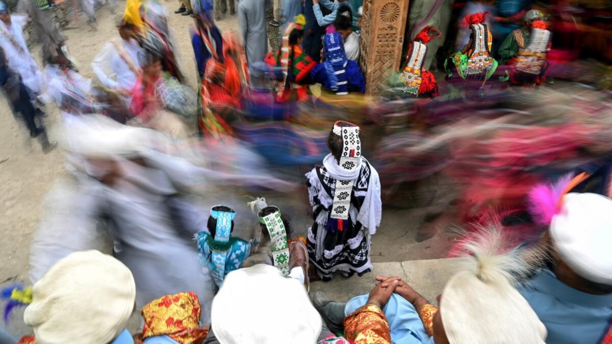 In a remote valley in Pakistan dozens of Kalash minority women dance to celebrate spring's arrival -- but as a gaggle of men scramble to catch them on camera, the community warns an influx of domestic tourists is threatening their unique traditions.  AAMIR QURESHI / AFP