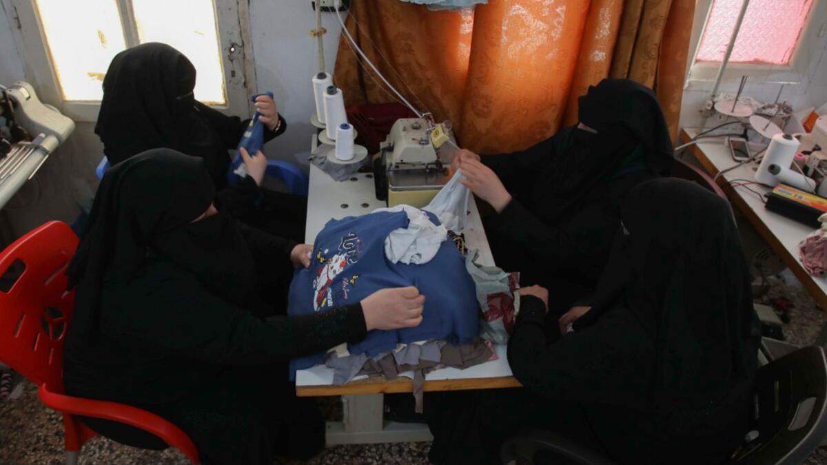 Colleagues of Hasna Dbeis (unseen), a 30-year-old former detainee in a Syrian-regime jail, work at a sewing workshop employing former female detainees, in the town of Maarat Nasrin, in the rebel-held part of the Syrian Idlib  Aaref WATAD / AFP