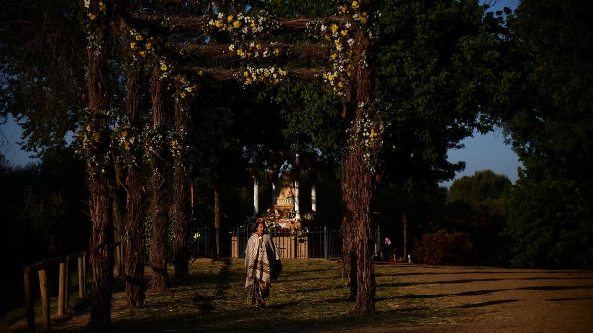 A pilgrim walks by an effigy of a Virgin near the Quema river in Villamanrique, during a pilgrimage to the village of El Rocio. CRISTINA QUICLER / AFP