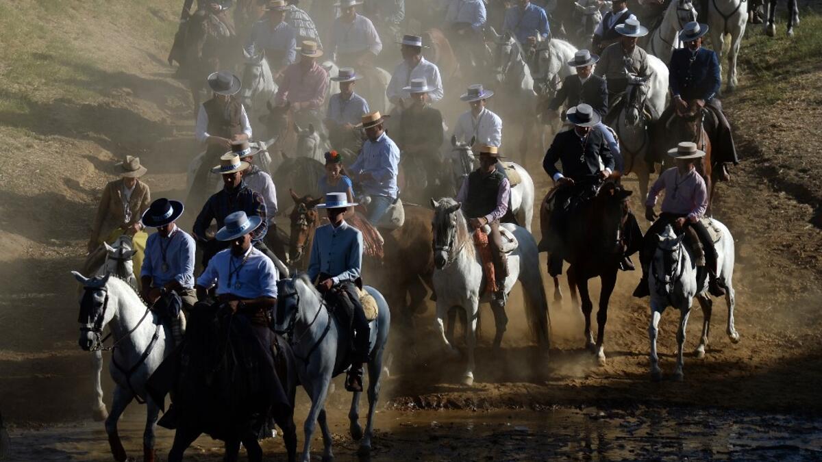 Pilgrims cross the Quema river in Villamanrique, during a pilgrimage on their way to the village of El Rocio.  CRISTINA QUICLER / AFP