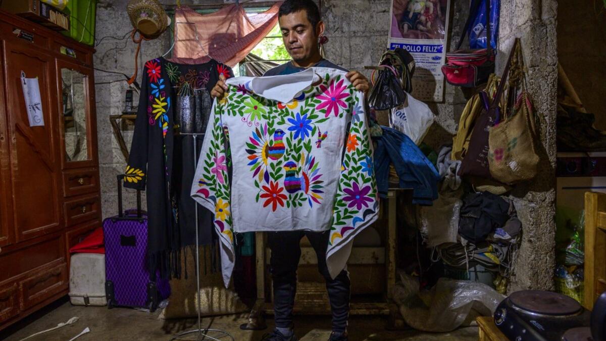 Mexican artisan of the Otomi ethnic group Oliver Teodoro Lopez, shows one of his designs at his workshop in San Nicolas Village, in Tenango de Doria, Hidalgo state, Mexico.  Pedro PARDO / AFP