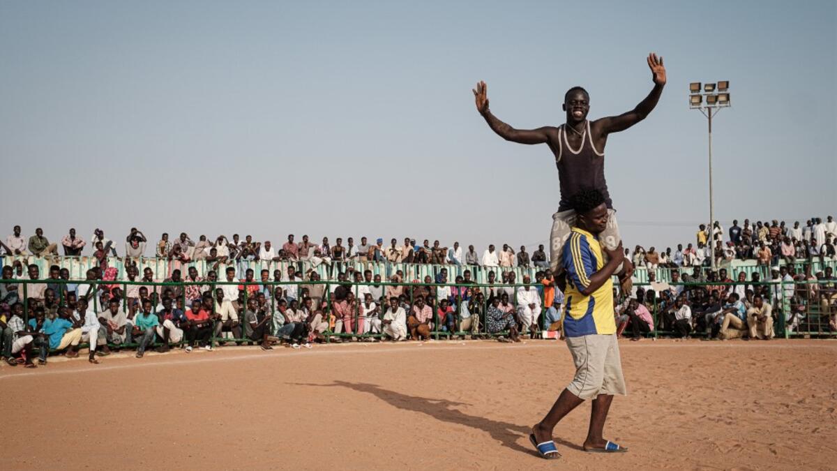A Sudanese wrestler reacts after winning during a traditional Nuba wrestling match at the Haj Youssef stadium in the district of Khartoum.  Yasuyoshi CHIBA / AFP