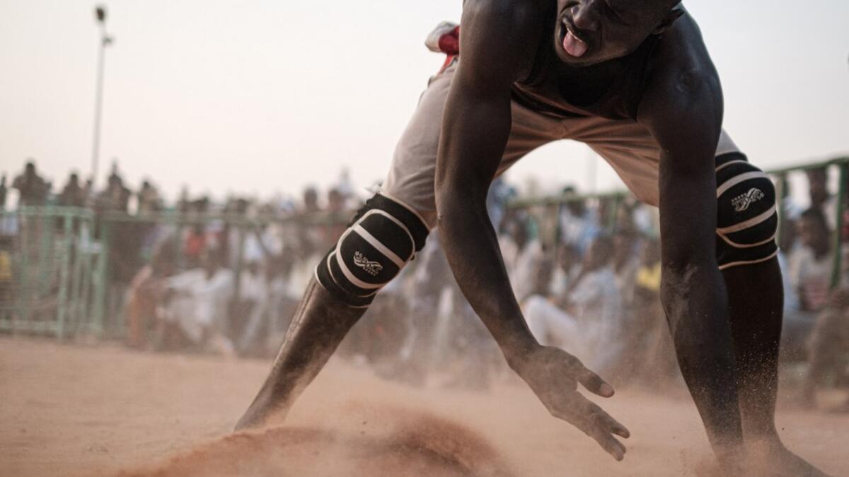 A Sudanese wrestler reacts during a traditional Nuba wrestling match at the Haj Youssef stadium in the district of Khartoum.  Yasuyoshi CHIBA / AFP