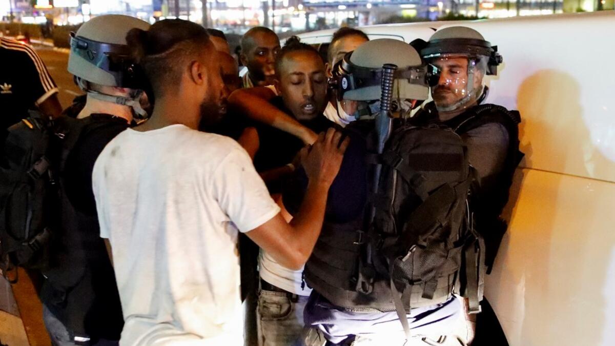 Members of the Ethiopian community of Israel face policemen during clashes in the Israeli coastal city of Netanya, during a protest against the killing of Solomon Tekah, a young man of Ethiopian origin, who was killed by an off-duty police officer.  JACK GUEZ / AFP